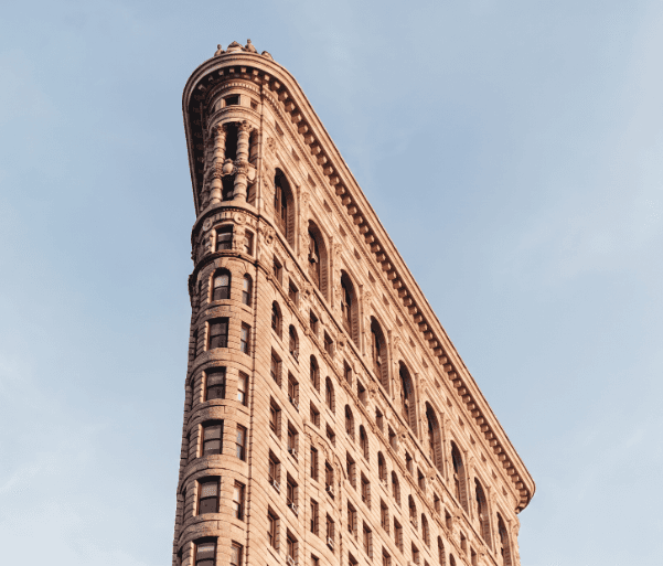 The Flatiron Building in the Flatiron District of Manhattan against a blue sky